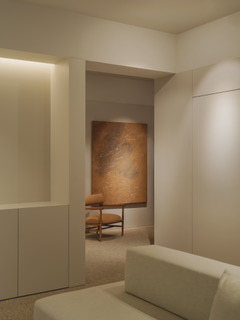 Acceso a la sala de espera con sillón y obra de arte del proyecto SDI28